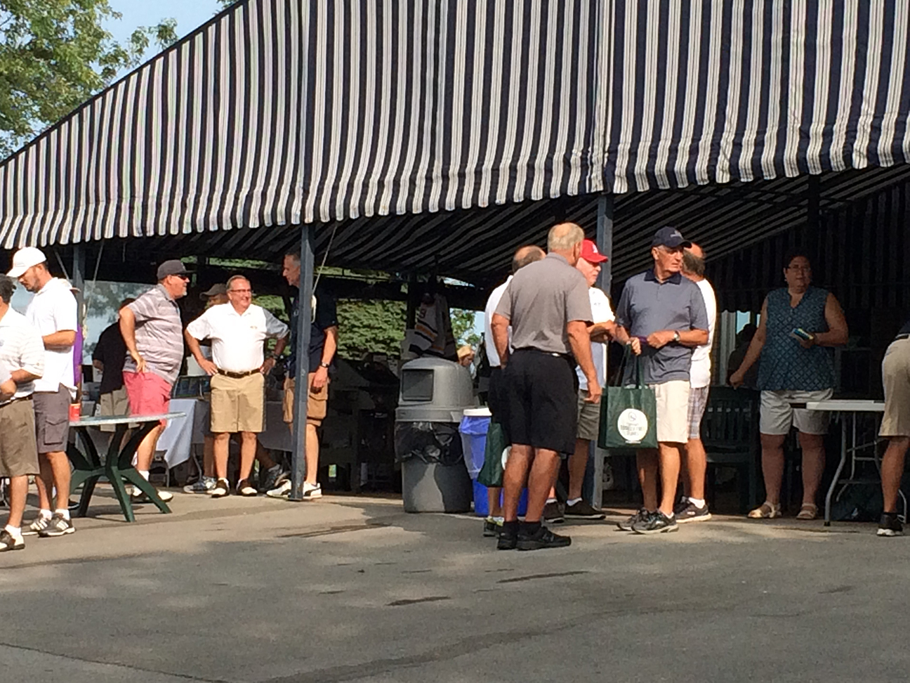 Community members under an outdoor tent
